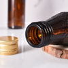 Fabricante de botellas de jarabe de vidrio ámbar recicladas de vidrio selladas de 100 ml con tapa de metal